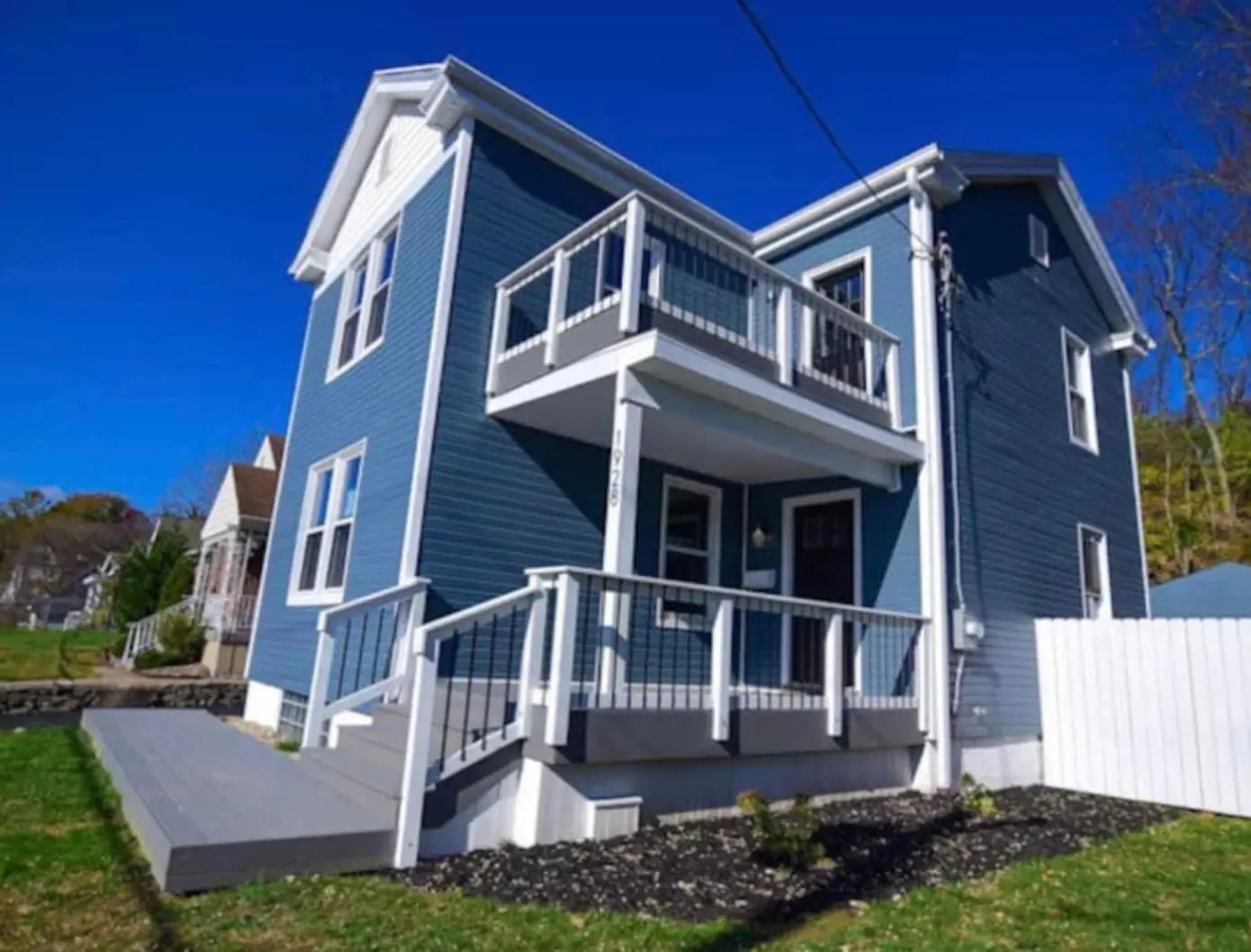 Blue two-story Dream Chasers home with a second-floor balcony.