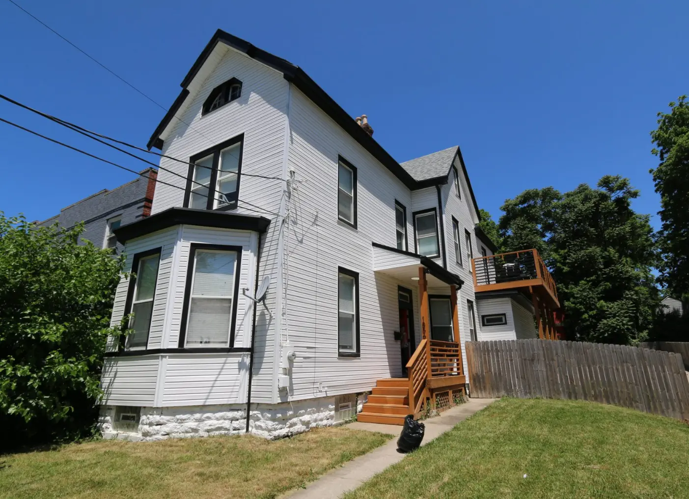 Two-story white Victorian-style Dream Chasers home with a covered porch.