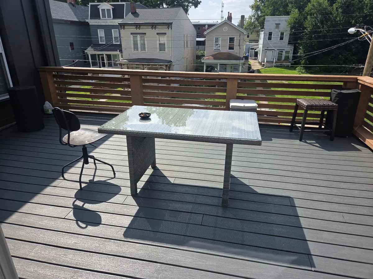 Second-story deck at one of our homes with a table and chairs.