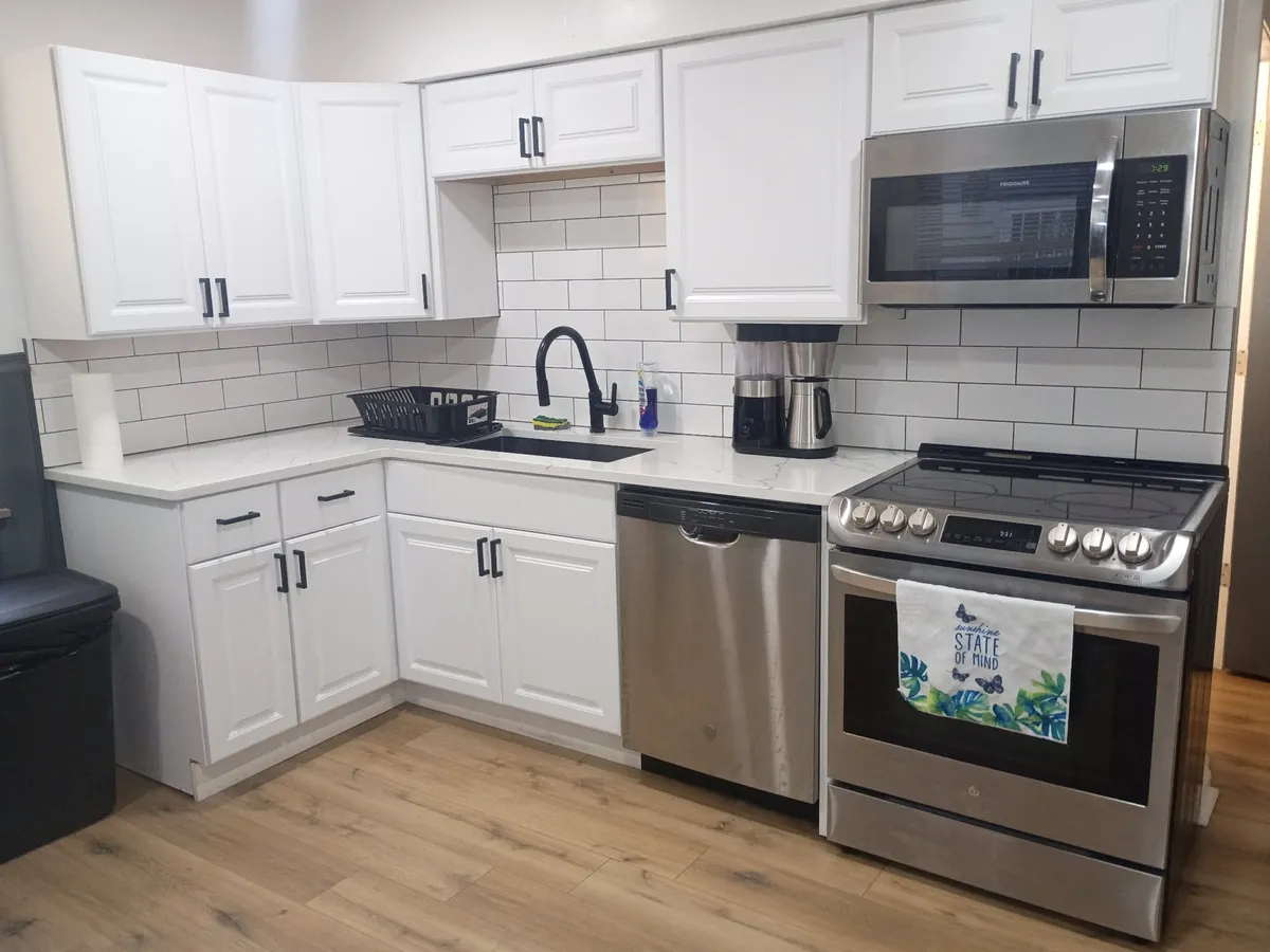 Kitchen in one of our homes with white cabinets and stainless appliances.